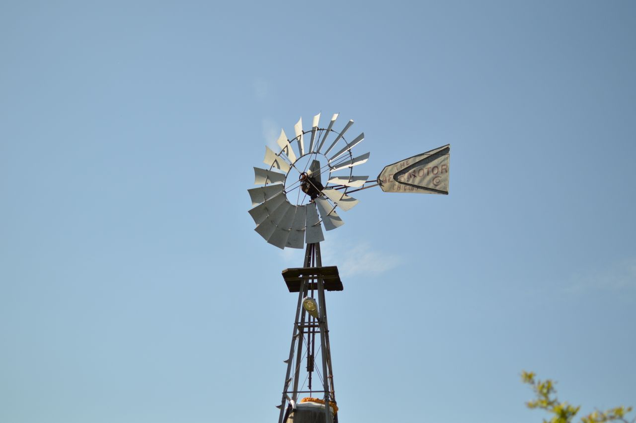 A classic windmill stands against a clear blue sky, symbolizing renewable energy and rustic charm.